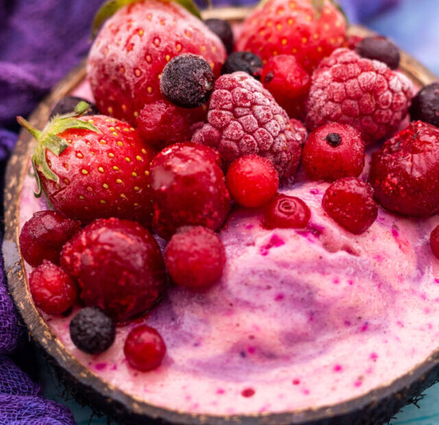 cropped-closeup-shot-fruit-shake-topped-with-frozen-strawberries-cranberries-coconut-bowl.jpg